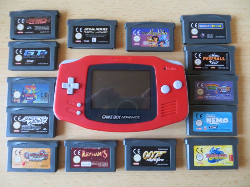 Roter Game Boy Advance, umgeben von 14 Spielemodulen, darunter Rayman 3, 007 NightFire und Findet Nemo