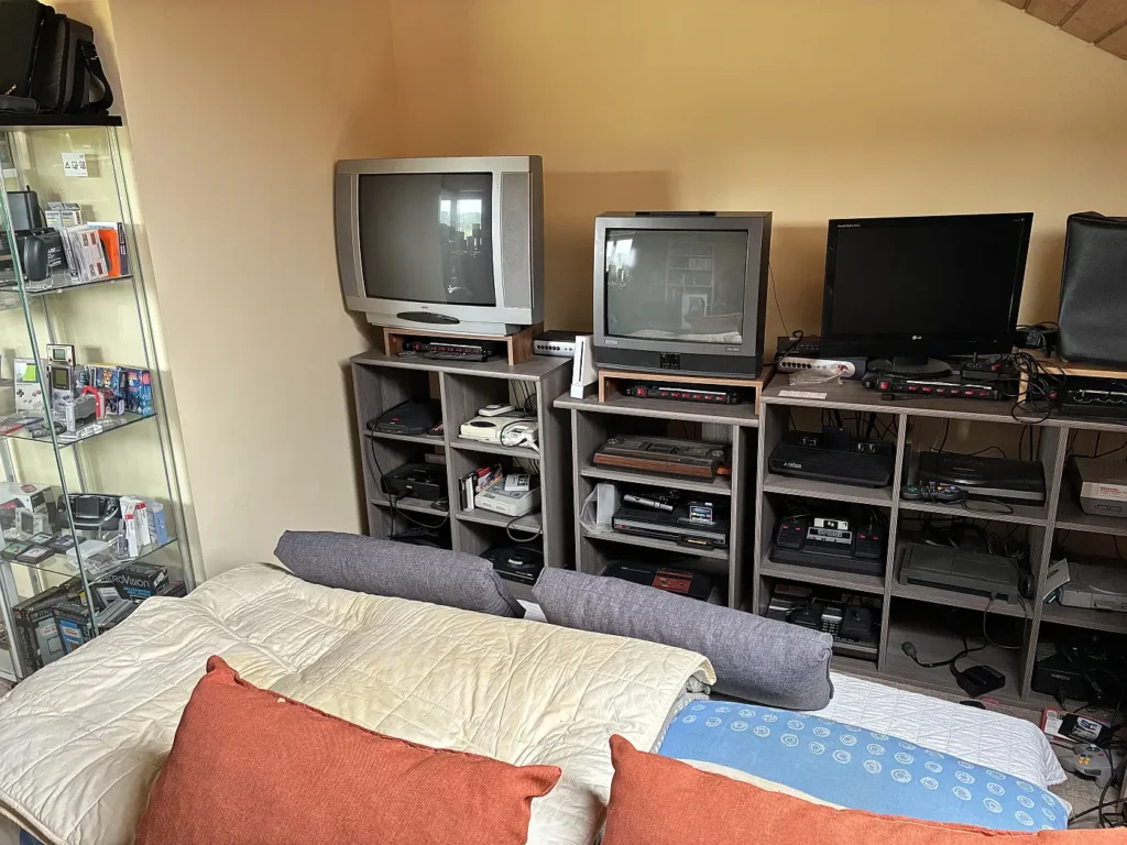 Konsolenregal mit mehreren Röhrenfernsehern und Retro-Konsolen im Jungsi-Zimmer